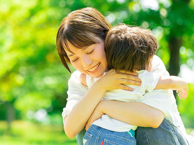 幼い子供を抱きしめる女性